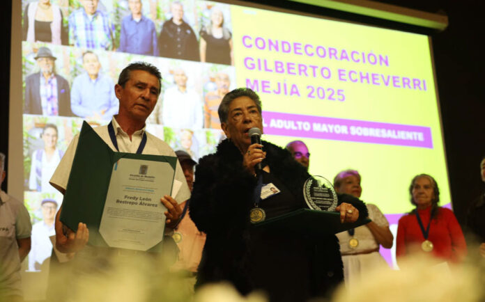 Personas mayores reciben la Condecoración Gilberto Echeverri Mejía por su liderazgo comunitario en Medellín.