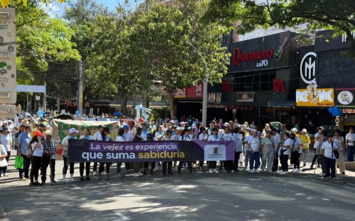 Personas mayores participan en una caminata comunitaria por las calles de El Poblado, Medellín.