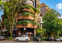 JAC Barrio Manila se integra a la Red Comuna 14 para fortalecer su comunicación comunitaria Edificio de arquitectura moderna y sostenible con fachada de ladrillo y vegetación en el barrio Manila, El Poblado, Medellín.