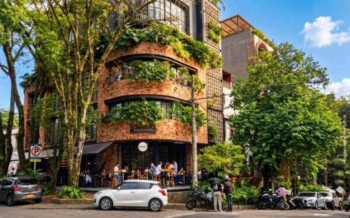 Edificio de arquitectura moderna y sostenible con fachada de ladrillo y vegetación en el barrio Manila, El Poblado, Medellín.
