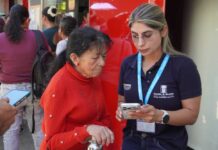 Presupuesto Participativo en El Poblado: menos votos y más preguntas sobre el futuro de la comuna Una funcionaria de la Alcaldía de Medellín acompaña a una mujer mayor durante la votación de Presupuesto Participativo.