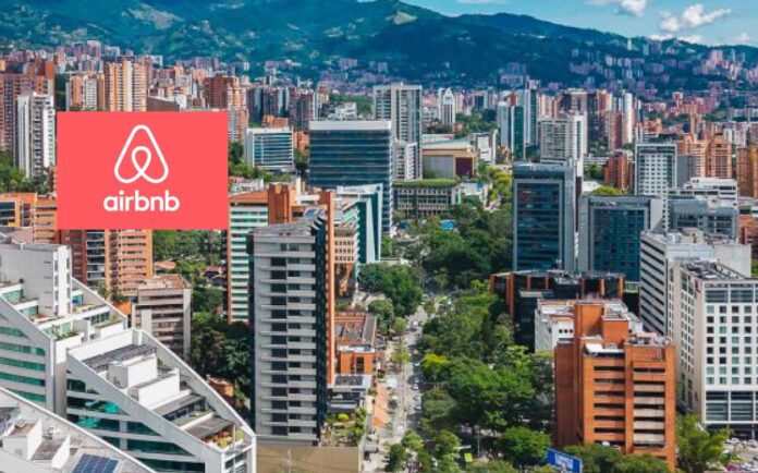 Panorámica de El Poblado, Medellín, con el logo de Airbnb superpuesto.